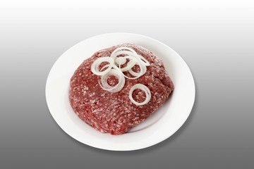 Minced meat, half ground beef, half ground pork, with onion rings, on a plate