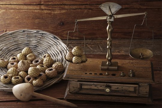 Antique scales weighing Salak or Snake Fruit (Salacca zalacca) on a wooden surface