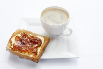 Porcelain plate with a cup of coffee and toast with apricot jam