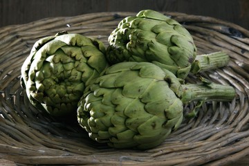 Fototapeta premium Three artichokes (Cynara cardunculus) in a basket
