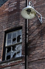 Old abandoned industrial brick building window with broken windows