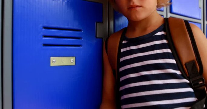 Schoolgirl using mobile phone in locker room 