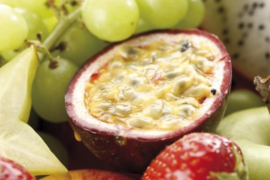 Half of a passion fruit, surrounded by fruit