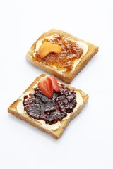 Two slices of toast, toasted slices of bread, strawberry jam and apricot jam