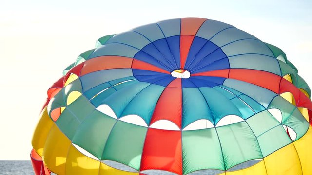 Close up Colorful parasailing provide services to tourists on sky in sunset time in travel and transport concept.