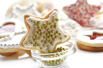 Still life, baking ingredients and Christmas cookies, golden sugar pearls