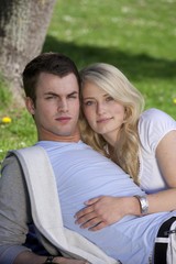 Young couple lying on a lawn in a park, spring