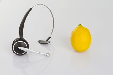 Headphones and a lemon as a symbol for healthy eating at work - obrazy, fototapety, plakaty