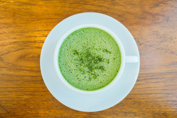 Hot green matcha latte in white cup