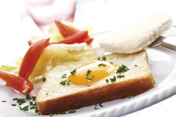 Fried egg on toast, heart shaped, nasturtium, salad and chives