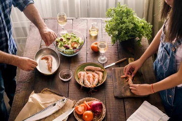 Papier Peint photo Cuisinier Couple cuisinant ensemble dîner de crevettes et salade de légumes