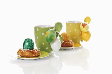 Coffee mugs with small savarins and Easter eggs
