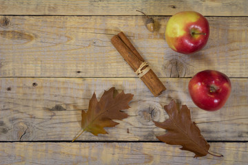Autumn  decor of leaves and apples frame a weathered wood plank background