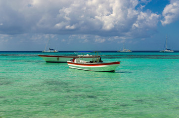Naklejka na ściany i meble Colorful wooden boats on azur beautiful Caribbean, Dominican Republic