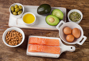 Selection of healthy fat sources on wooden background