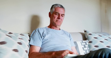 Senior man using digital tablet in bedroom - Powered by Adobe