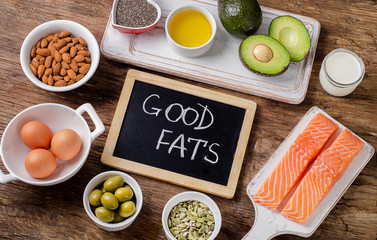 Selection of healthy fat sources on wooden background