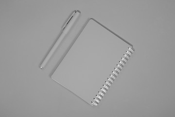 Gray notepad and pen on a gray background.