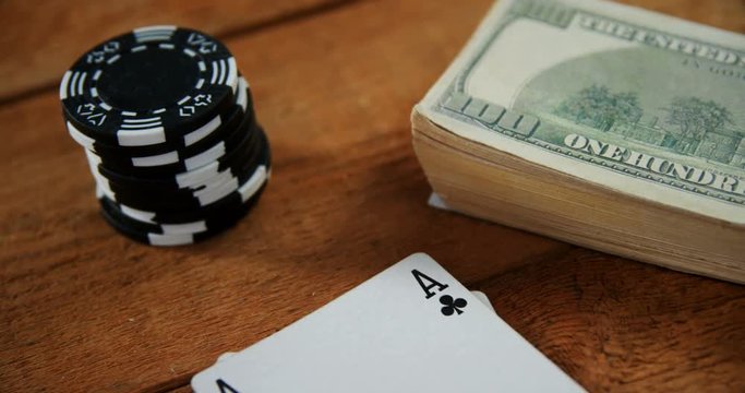Close-up of playing cards, dollar and casino chips on poker table 