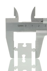 Calipers with a puzzle piece, symbolic image for analysis of a piece