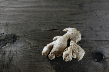 Ginger (Zingiber officinale) rhizome on a rustic wooden surface