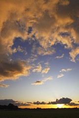 Dramatic sky with clouds illuminated from below by the late evening sun at sunset, landscape in Oberalsterniederung Nature Reserve, Tangstedt, Schleswig-Holstein, Germany, Europe