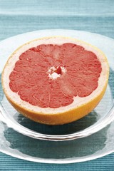 Half of a red grapefruit, Ruby Star, on a glass plate
