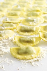 Homemade ravioli on a floured board