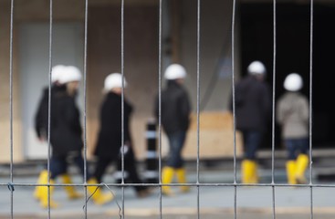 People wearing hard hats and rubber boots behind a hoarding at the Elbe Philharmonic Hall, Hamburg, Germany, Europe © imageBROKER