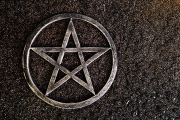 Gray metal pentagram on slate background with water drops - obrazy, fototapety, plakaty