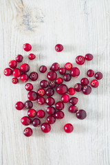 fresh cranberries on white wooden surface