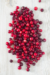 fresh cranberries on white wooden surface