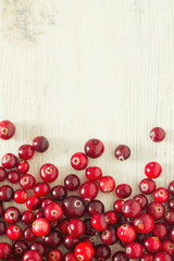 fresh cranberries on white wooden surface