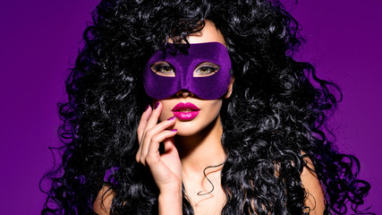 Fototapeta premium Beautiful woman with black hairs and violet theatre mask on face.