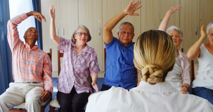 Doctor teaching exercise to senior people 