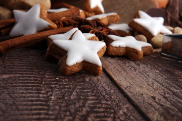 Christmas cookies and spices on brown wooden background.