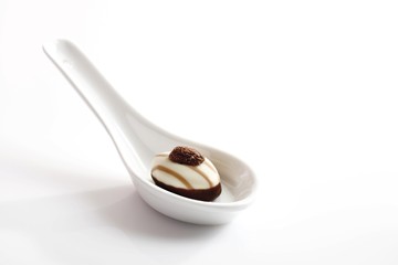 Porcelain spoon with a chocolate praline