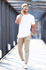 Handsome young man using his mobile phone in the street.