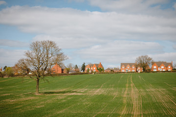 a typical english UK green countryside landscape mixed land use woods and farming