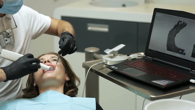 Dentist scanning the teeth of patient with a d scanner