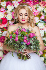 beautiful woman posing in wedding dress flowers wall background