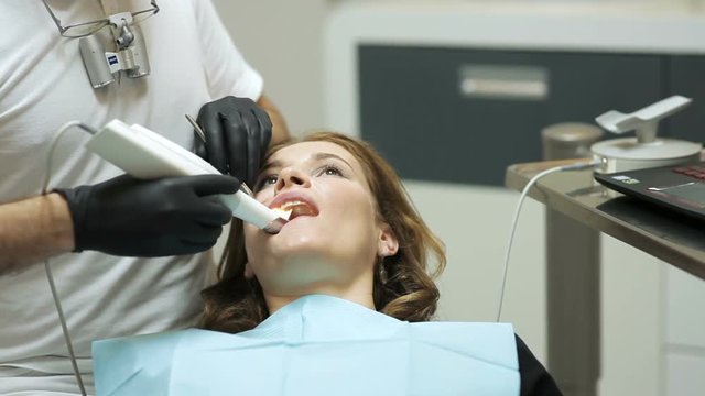 Dentist scanning the teeth of patient with a d scanner
