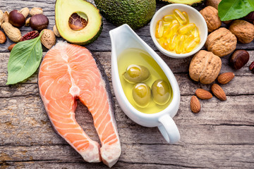 Selection food sources of omega 3 and unsaturated fats. Superfood high vitamin e and dietary fiber for healthy food. Almond,pecan,hazelnuts,walnuts,olive oil,fish oil and salmon on wooden background.