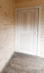 Wooden interior. White door in the corner