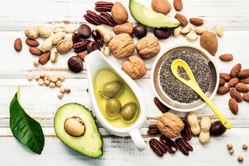 Tuinposter Selection food sources of omega 3 and unsaturated fats. Superfood high vitamin e and dietary fiber for healthy food. Almond ,pecan,hazelnuts,walnuts and olive oil on stone background. © kerdkanno