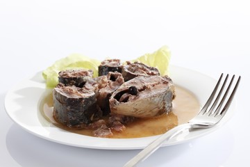 Sardines from the tin on a plate with salad and fork