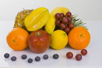 Pineapple, apple, clementines, lemon, star fruit, blueberries and red grapes