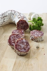 Gourmet salami, premium salami with garlic and parsley on a wooden board
