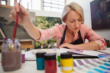 Woman selecting a paintbrush