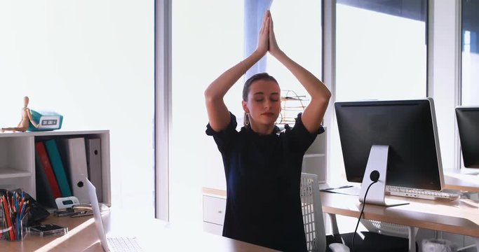 Female executive doing yoga 